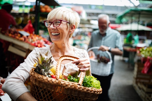 Senior couple buying fresh vegetables at the local market